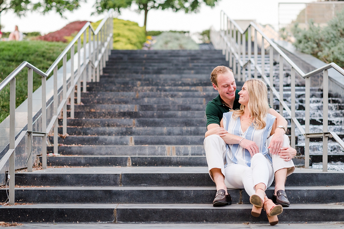 Julia and Thomas sitting on the steps during their spring engagement session at the VMFA in downtown Richmond. Photography by Richmond wedding photographer Kailey Brianne Photography. 