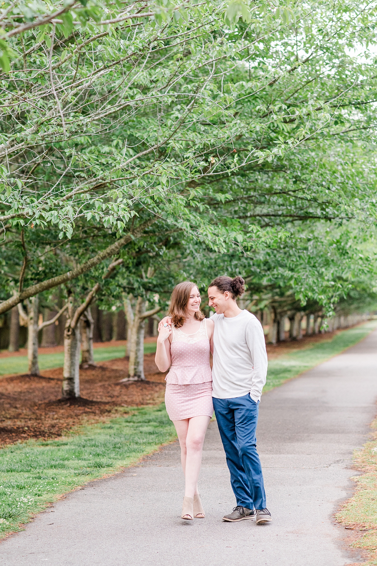 Couple walking down tree lined path during Spring Red Wing Park Engagement Session. Photography by Virginia Beach Wedding Photographer Kailey Brianne Photography. 