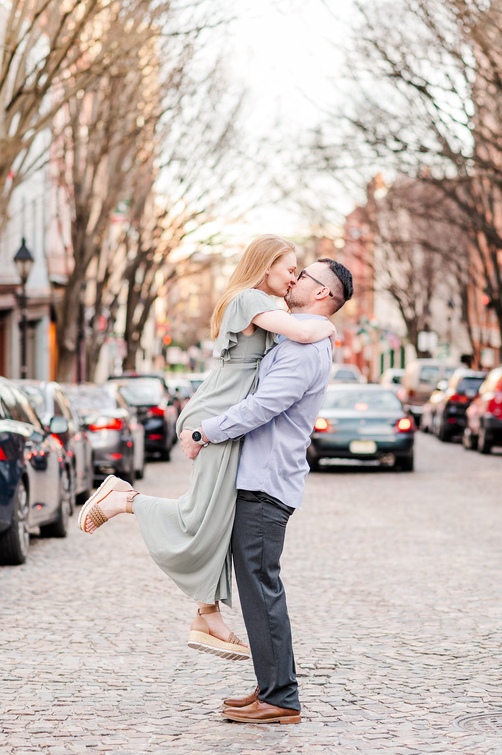 Scissor Kick Kiss in Middle of The Street during Downtown Richmond Engagement Session by Urban Farmhouse. Wedding Photographer Kailey Brianne Photography