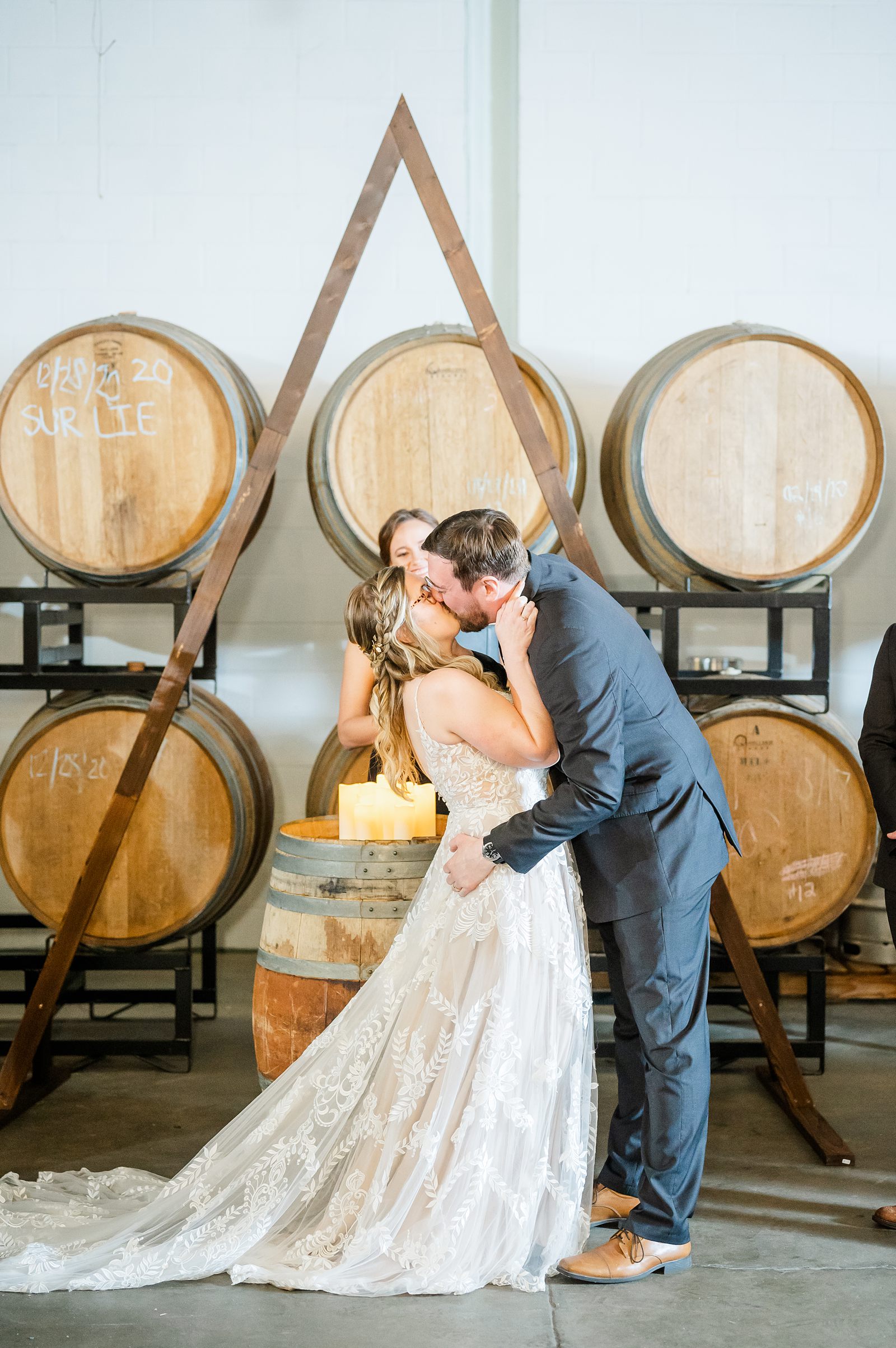 Bride and Groom Kiss During Ceremony at Triple Crossing Beer Wedding